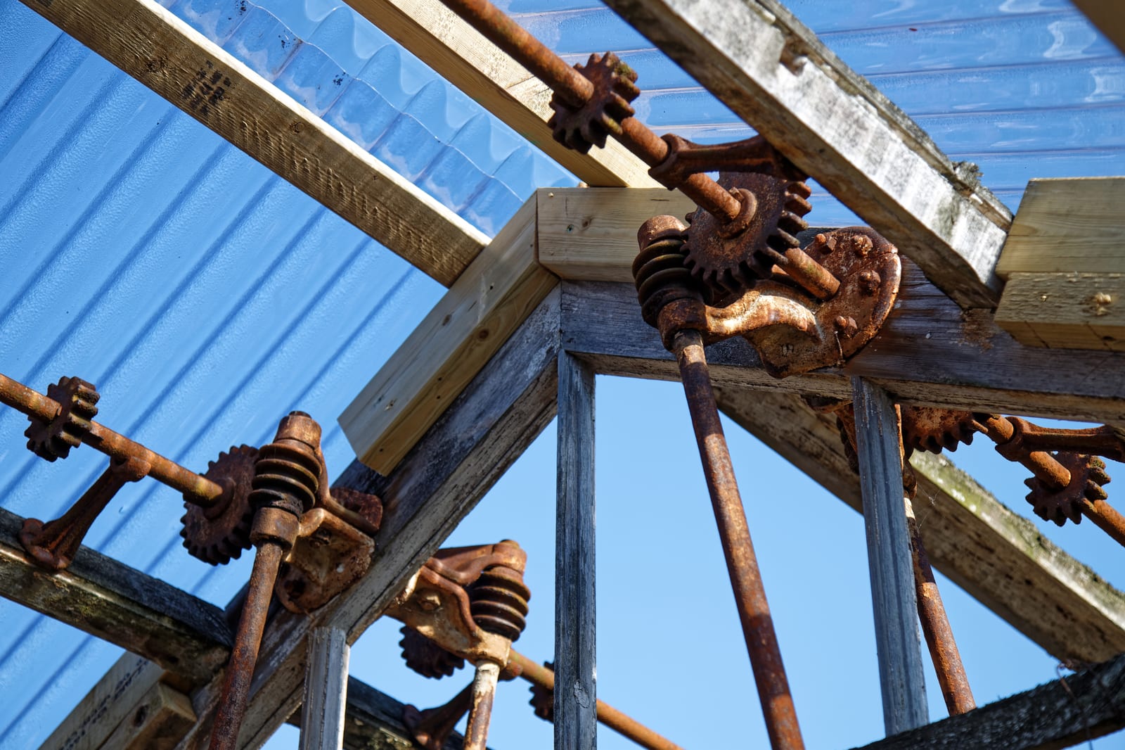 Close-up of greenhouse plastic being secured with wiggle wire and channel on an aluminum frame